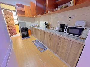 a kitchen with a counter top and a microwave at Luxurious Homely Apt 6 in Kisumu