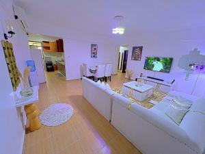 a living room with a white couch and a table at Luxurious Homely Apt 6 in Kisumu