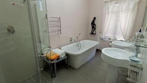 y baño con bañera, 2 lavabos y ducha. en Alba House Guest House, en Paarl