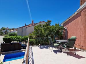 a patio with a table and chairs next to a pool at Hestia Apartments in Rovinj