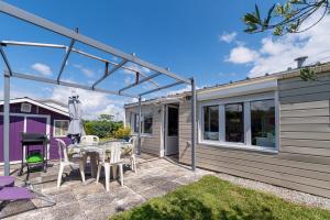 Un patio con mesa y sillas y una casa. en Mobilhome rénové Sarzeau, en Sarzeau