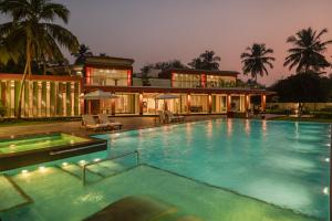 a large swimming pool in front of a house at Kidena House in Goa Velha