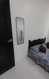 a bedroom with a bed and a mirror on the wall at Alya Homestay 295 Sik in Sik
