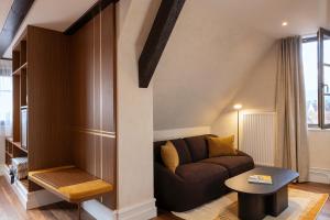 a living room with a couch and a table at Hotel Le Colombier in Obernai
