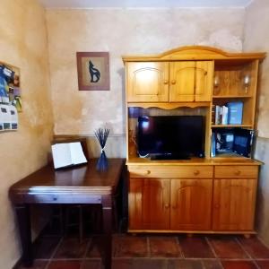 a room with a desk and a cabinet with a television at Casa Vaélico in Arenas de San Pedro