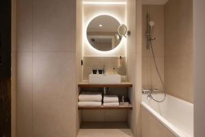 a bathroom with a sink and a mirror at Hotel Le Colombier in Obernai