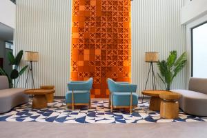 a waiting area with chairs and tables in a lobby at Lakeside Residences by NLA in Bang Tao Beach