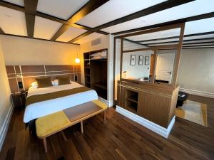 a bedroom with a bed and a large window at Hotel Le Colombier in Obernai