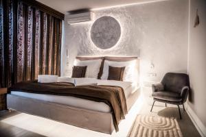 茲林的住宿－派茲奧歐諾酒店，一间卧室配有一张大床和一把椅子