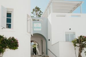 a white building with a sign on it at Sunrise Paros by Mr and Mrs White in Naousa +22 photos