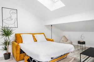 ein Schlafzimmer mit einem Bett und einem Sofa in der Unterkunft COCON - Appartement neuf et confort in Saint-Étienne