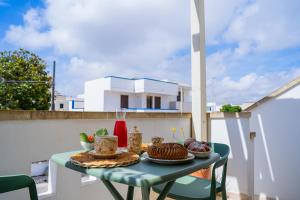 a table with food on top of a balcony at La Casa al mare Torre San Giovanni in Torre San Giovanni Ugento