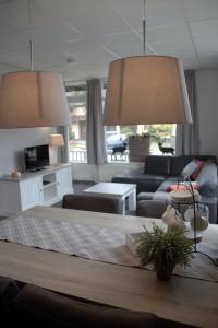 sala de estar con mesa y 2 lámparas en Apartments Bommels, en Vierhouten