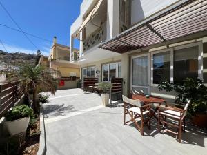 a patio with a wooden table and two chairs at Artemis Rooms - Beach at Your Doorstep in Platanias