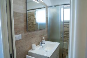 a bathroom with a sink and a mirror at La Casa al mare Torre San Giovanni in Torre San Giovanni Ugento
