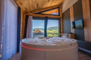 eine große Badewanne in einem Raum mit Fenster in der Unterkunft Abant Sedir Park in Bolu