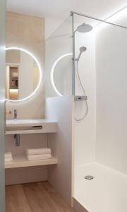 La salle de bains est pourvue d'une douche et d'un miroir. dans l'établissement Résidence Hôtelière les Acanthes, à Hossegor