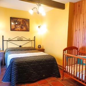 1 dormitorio con 1 cama y 1 cuna en Casa Vaélico, en Arenas de San Pedro