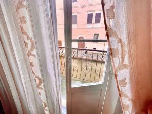 een raam met een deur en een balkon bij L'ENCANTO DE LUNA -Una Casa Autentica Comacchiese in Comacchio