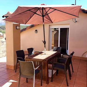 a wooden table with an umbrella on a patio at Casa Vaélico in Arenas de San Pedro