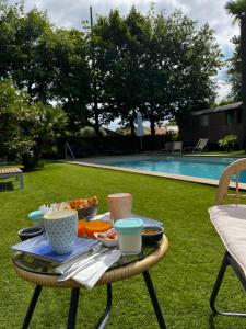 - un plateau de nourriture sur une table à côté de la piscine dans l'établissement Villa Herbert, Chambres d'Hôtes et Gîte, à Andernos-les-Bains
