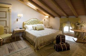sypialnia z łóżkiem i krzesłem z walizką w obiekcie Villa Cordevigo w mieście Cavaion Veronese