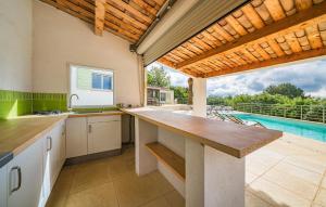 a kitchen with a counter and a swimming pool at House With Pool Panoramic View in Saint-Cézaire-sur-Siagne