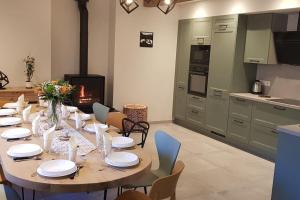 a dining room with a table and a kitchen at Gîte Chez Arnaoutou in Beaudéan