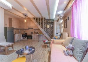 a living room with a couch and a kitchen at AGALI HOUSE in Limenaria