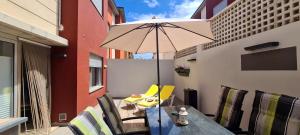 een tafel en stoelen met een parasol op een balkon bij Duplex Pozo Canary in Pozo Izquierdo