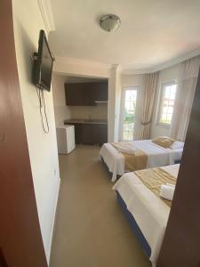 a hotel room with two beds and a flat screen tv at EON DALYAN BOUTIQIE HOTEL in Ortaca
