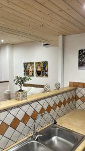 a kitchen with a sink and two paintings on the wall at Il Moro in Carini