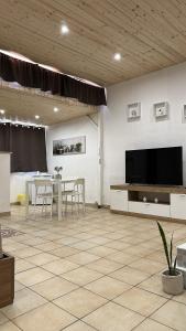 a living room with a television and a table and chairs at Il Moro in Carini