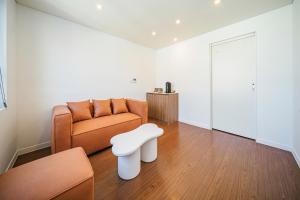 una sala de estar con un sofá y un taburete en Hotel Yeon, en Seogwipo