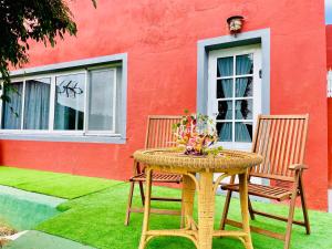 a wicker table and two chairs sitting in front of a building at Casa El Potrero in Mocanal