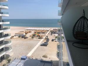 een balkon met uitzicht op het strand van een gebouw bij SUNDREAM by the beach in Mamaia