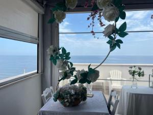a table with a vase with flowers on it at Palese Profumo di Mare in Santo Spirito