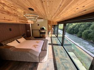 a bedroom with a bed and a view of a river at TUVA VİLLA Bungalov in Çamlıhemşin