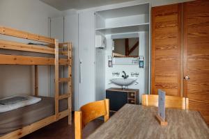1 dormitorio con litera, mesa y lavamanos en Gruppenhaus Lindenhof Churwalden, en Churwalden