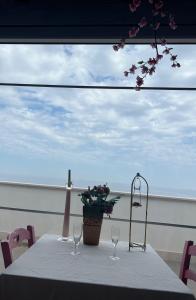 una mesa con copas de vino y un jarrón en ella en Palese Profumo di Mare, en Santo Spirito