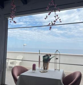 a table with a white table cloth and flowers on a balcony at Palese Profumo di Mare in Santo Spirito