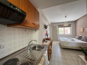 a kitchen with a sink and a bed in a room at Artemis Rooms - Beach at Your Doorstep in Platanias