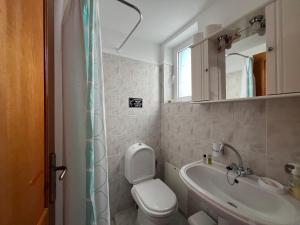 a bathroom with a toilet and a sink and a mirror at Artemis Rooms - Beach at Your Doorstep in Platanias +92 photos