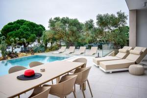 a patio with a table and chairs and a pool at Presidential Beach Villa in Alyfantá