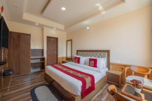 a hotel room with a bed and a television at Hotel Charming Hills By Him Haults Hospitality in Shimla +2 photos