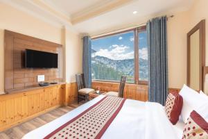 a bedroom with a bed and a large window at Hotel Charming Hills By Him Haults Hospitality in Shimla