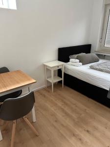 a bedroom with a bed and a desk and a table at Cheema Apartments Frankfurt am Main in Frankfurt/Main