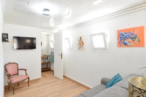 a living room with a couch and a chair at L'Escapade de Creully - Appt 2p avec grande terrasse in Creully