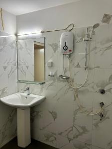 Himo Guest Inn في دهيفالا: حمام مع حوض ودش مع مرآة