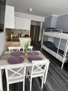 Camera con tavolo, sedie e letto a castello. di Apartament Planeta 209 a Mielno Altre 9 foto